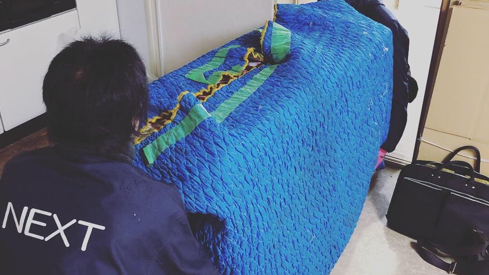 養生した家具を運び出す作業スタッフ