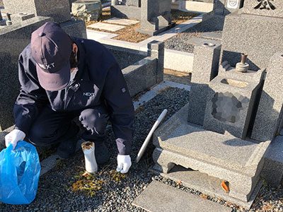 墓石まわりの草を取るスタッフ