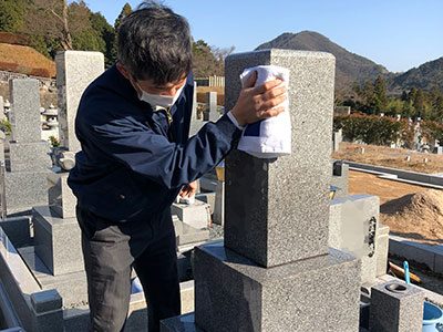 墓石を水で洗うスタッフ