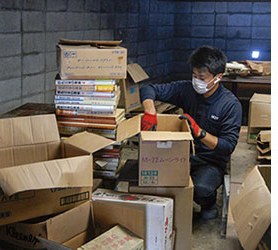 段ボールに書籍を詰める作業員
